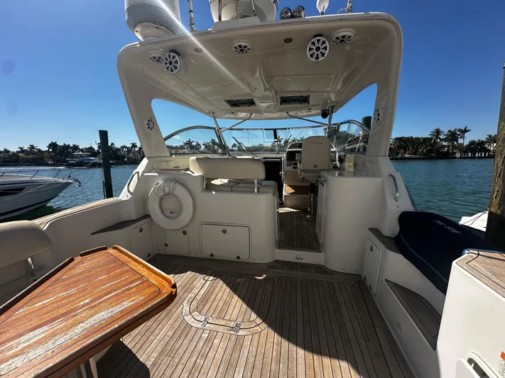  Yacht Photos Pics 2006 Chris-Craft 43 Roamer yacht interior with wooden deck and seating, docked by the water.