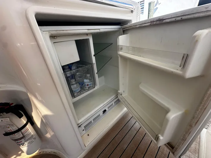  Yacht Photos Pics Open fridge on 2006 Chris-Craft 43 Roamer yacht, showing stocked beverages and fire extinguisher nearby.