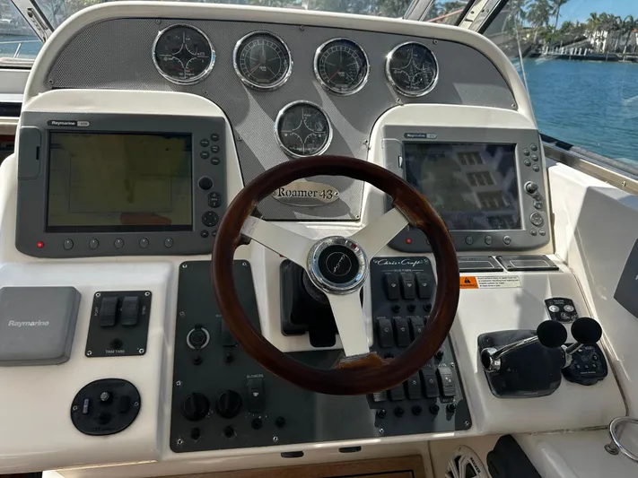  Yacht Photos Pics 2006 Chris-Craft 43 Roamer helm with dual navigation screens and classic wooden steering wheel.