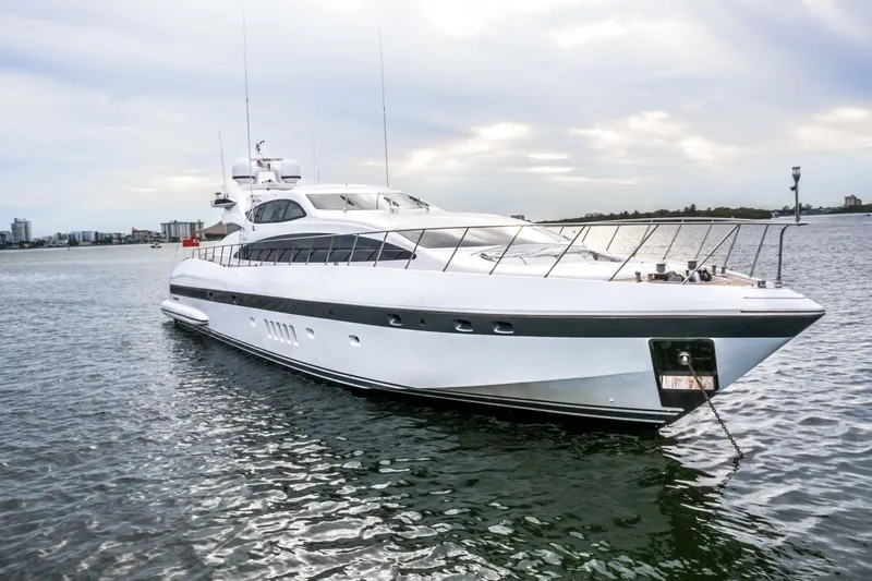 Daya Yacht Photos Pics Luxurious 2007 Mangusta 105 yacht on calm waters under a cloudy sky.