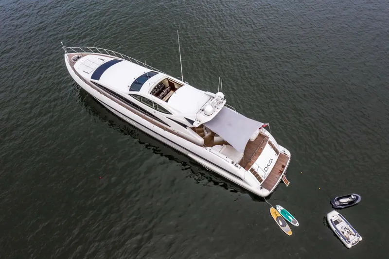 Daya Yacht Photos Pics Aerial view of 2007 Mangusta 105 yacht with paddleboards and dinghies on water.