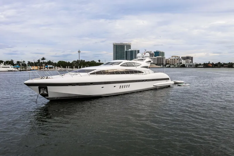 Daya Yacht Photos Pics Luxurious 2007 Mangusta 105 yacht on calm waters with city skyline backdrop.