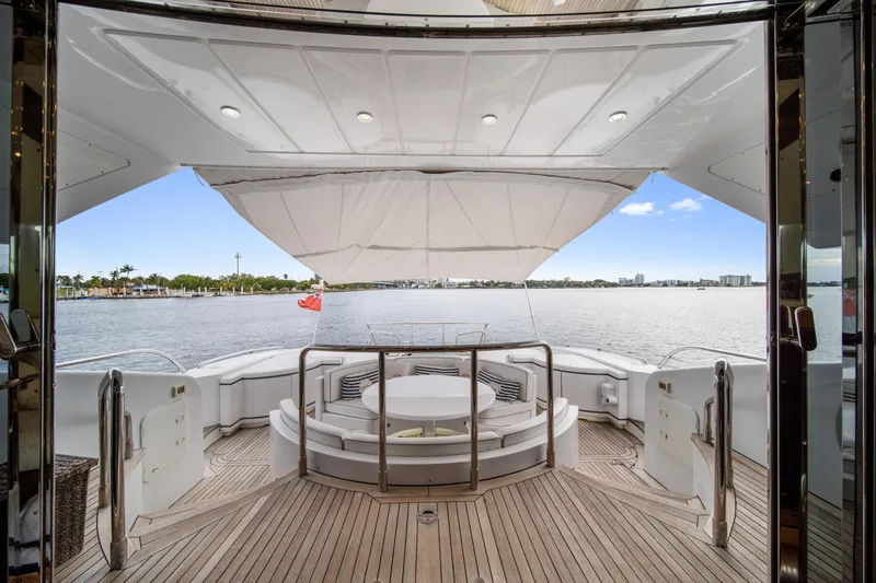 Daya Yacht Photos Pics Luxurious 2007 Mangusta 105 yacht deck with elegant seating and scenic waterfront view.