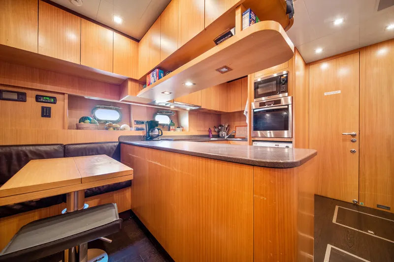 Daya Yacht Photos Pics Luxurious 2007 Mangusta 105 yacht kitchen with modern appliances and wooden cabinetry.