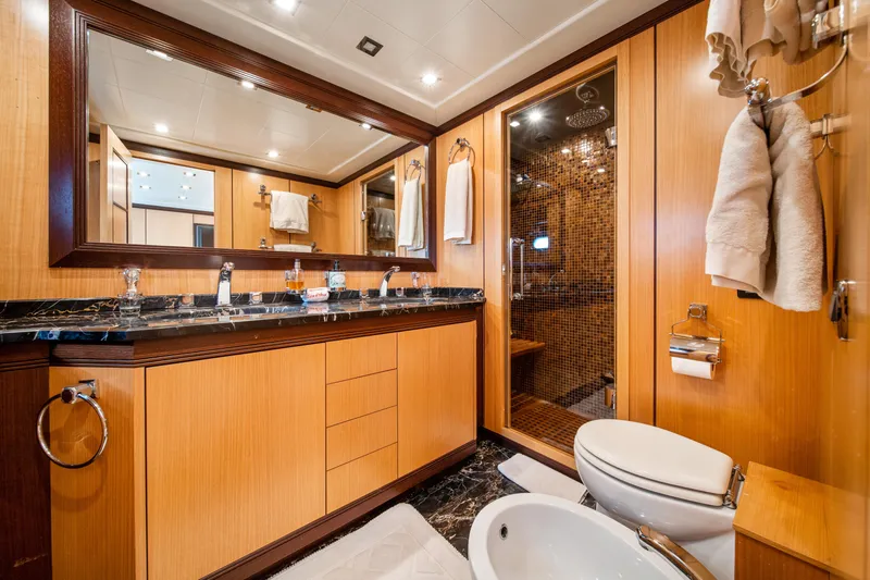 Daya Yacht Photos Pics Luxurious 2007 Mangusta 105 yacht bathroom with wood accents and modern fixtures.