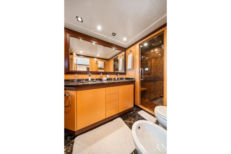 Daya Yacht Photos Pics Luxurious bathroom in 2007 Mangusta 105 yacht with wood accents and modern fixtures.