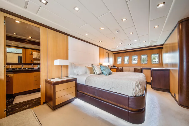 Daya Yacht Photos Pics Luxurious bedroom interior of 2007 Mangusta 105 yacht with elegant wood finishes.