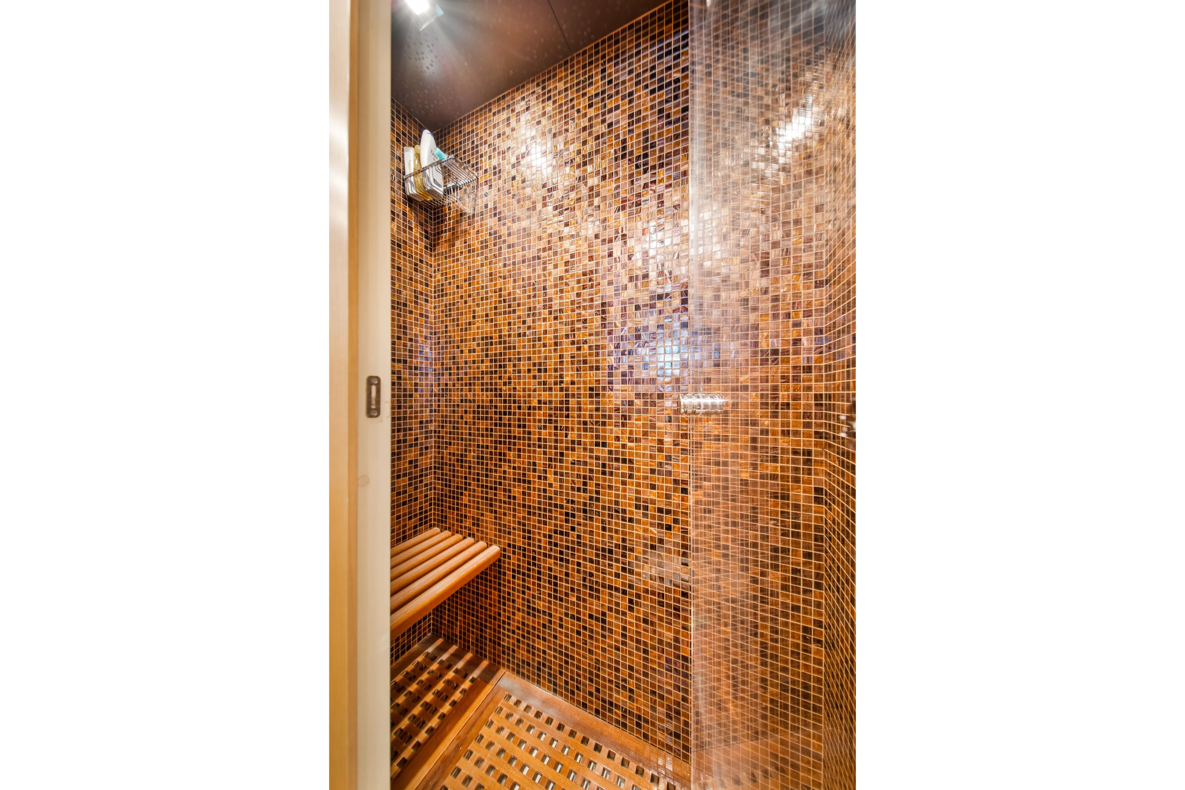 Daya Yacht Photos Pics Luxurious mosaic-tiled shower in 2007 Mangusta 105 yacht, featuring wooden bench and modern fixtures.
