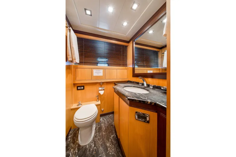Daya Yacht Photos Pics Luxurious bathroom in 2007 Mangusta 105 yacht with marble countertop and wooden accents.