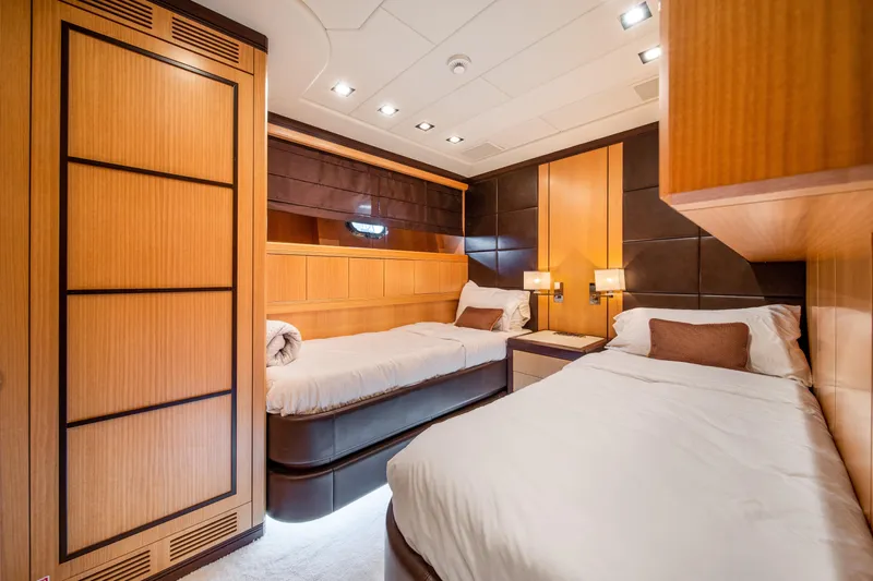 Daya Yacht Photos Pics Luxurious 2007 Mangusta 105 yacht cabin with twin beds and elegant wood paneling.