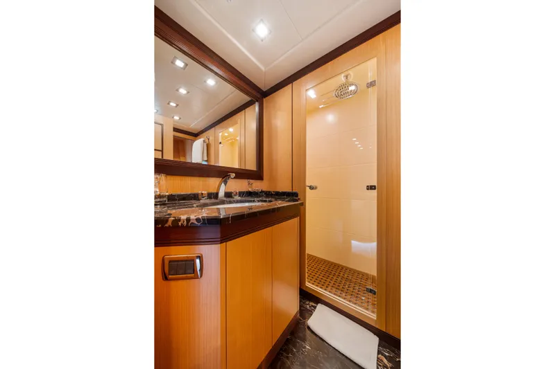 Daya Yacht Photos Pics Luxurious bathroom in 2007 Mangusta 105 yacht with wooden cabinetry and glass shower.