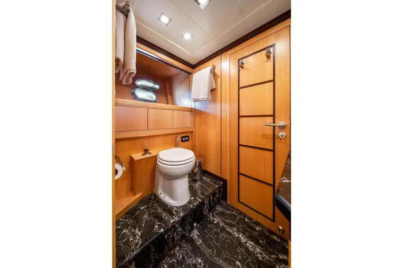 Daya Yacht Photos Pics Luxurious 2007 Mangusta 105 yacht bathroom with wood paneling and marble flooring.