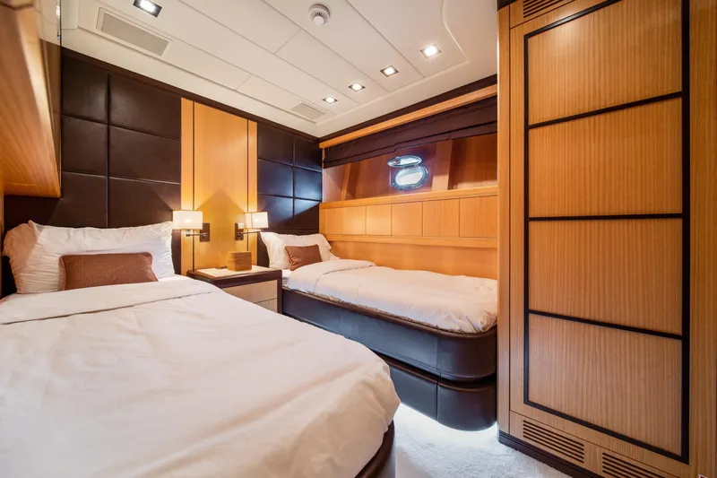 Daya Yacht Photos Pics Luxurious 2007 Mangusta 105 yacht cabin with twin beds and elegant wood paneling.