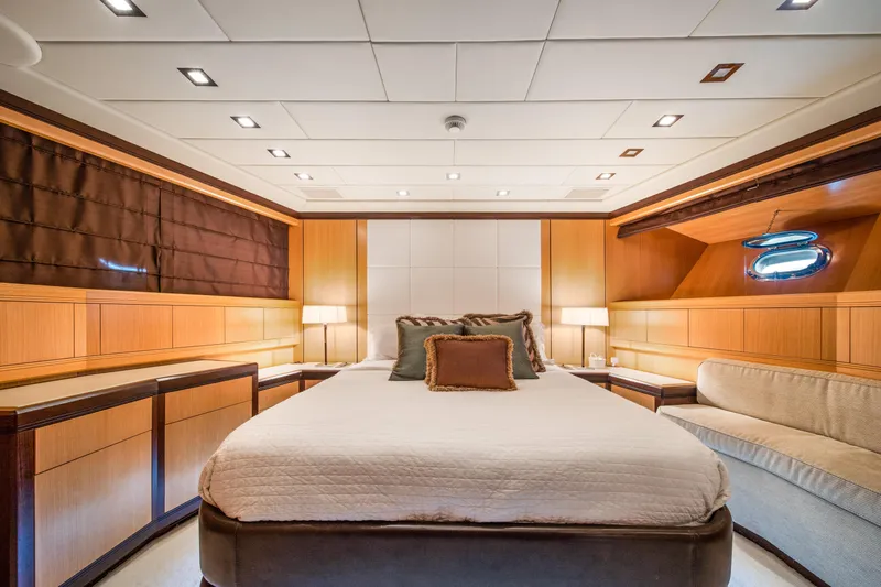 Daya Yacht Photos Pics Luxurious bedroom interior of 2007 Mangusta 105 yacht with elegant wood paneling.