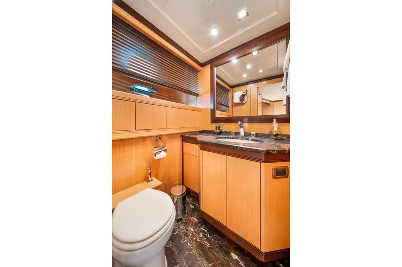 Daya Yacht Photos Pics Luxurious 2007 Mangusta 105 yacht bathroom with wood cabinetry and marble countertop.