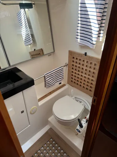  Yacht Photos Pics 2010 Dufour 45E Performance yacht bathroom with modern fixtures and striped towels.