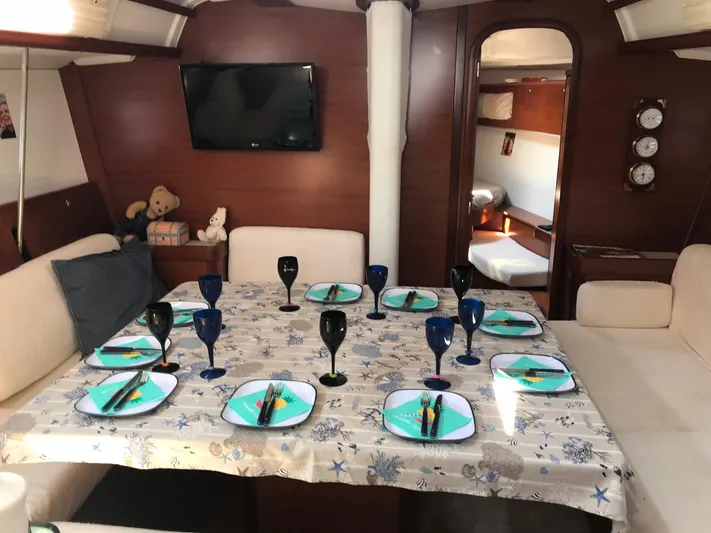  Yacht Photos Pics Interior of 2010 Dufour 45E Performance yacht, dining area set with plates and glasses.