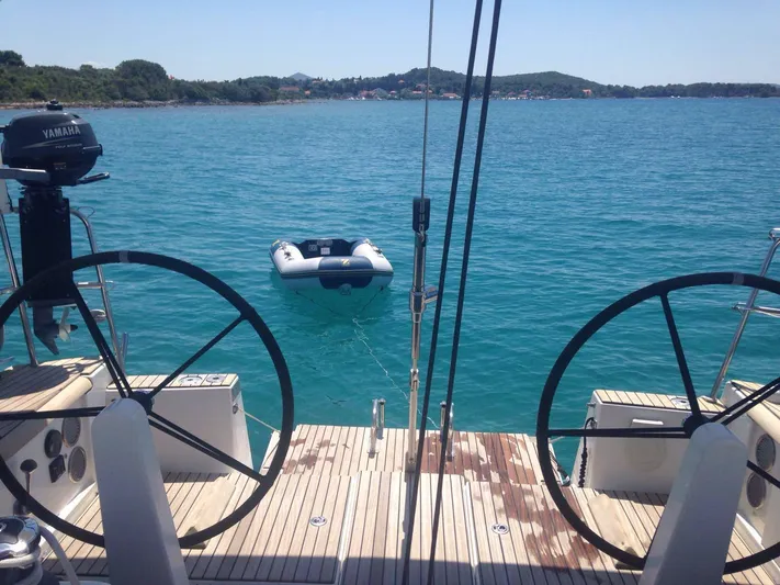  Yacht Photos Pics Dufour 45E Performance 2010 yacht with dual steering wheels, anchored near a serene coastline.