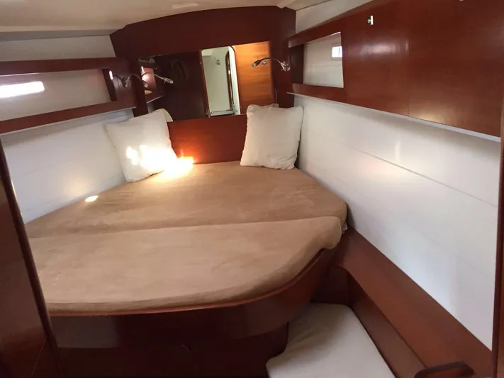  Yacht Photos Pics Cozy cabin interior of 2010 Dufour 45E Performance yacht with wooden finish and comfortable bedding.