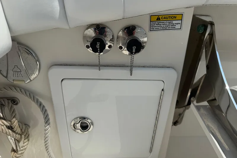  Yacht Photos Pics 2018 Regulator 31 boat controls and caution label, featuring flush fittings and storage compartment.