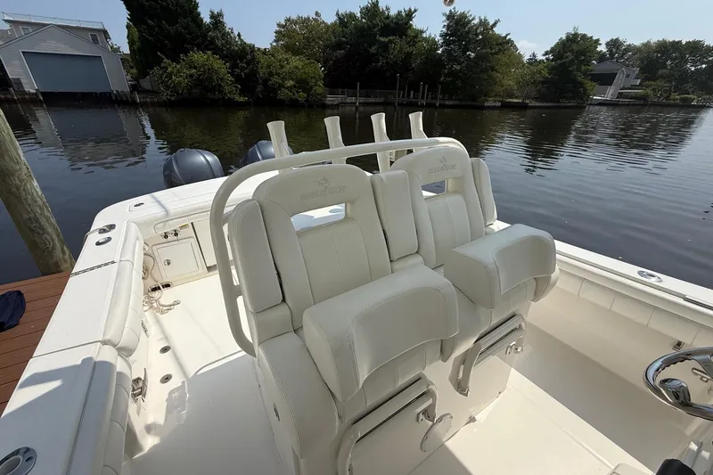  Yacht Photos Pics 2018 Regulator 31 boat with white seating, docked by a calm waterfront.