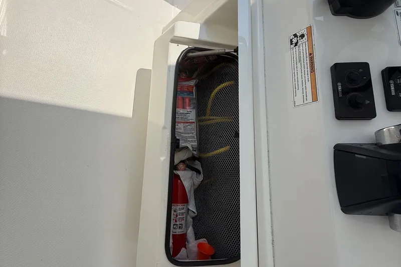  Yacht Photos Pics Storage compartment on 2018 Regulator 31 boat with safety equipment and controls.