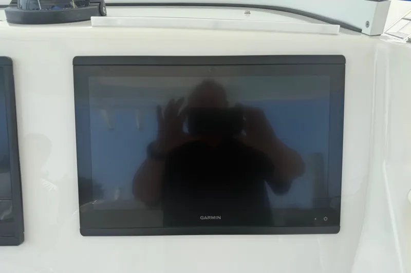  Yacht Photos Pics Garmin display on 2018 Regulator 31 boat dashboard, reflecting a person taking a photo.