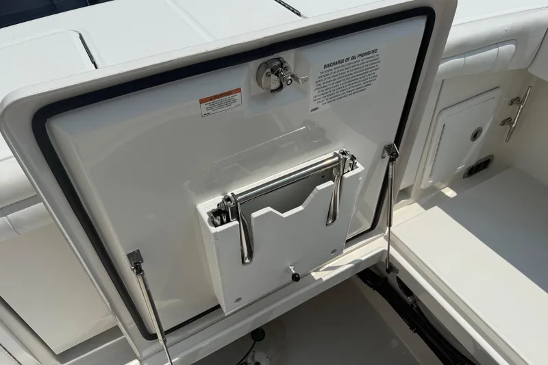  Yacht Photos Pics 2018 Regulator 31 boat storage compartment with open hatch and safety warning.