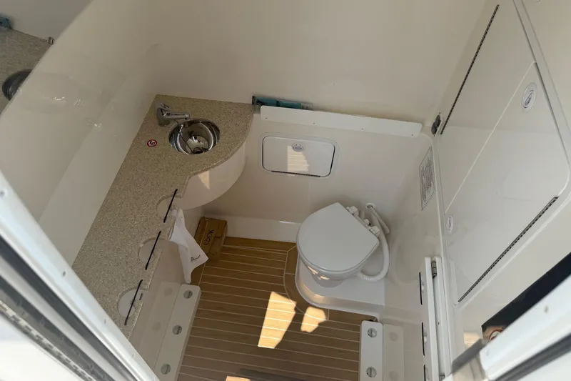  Yacht Photos Pics 2018 Regulator 31 boat bathroom with sink, toilet, and storage cabinets.