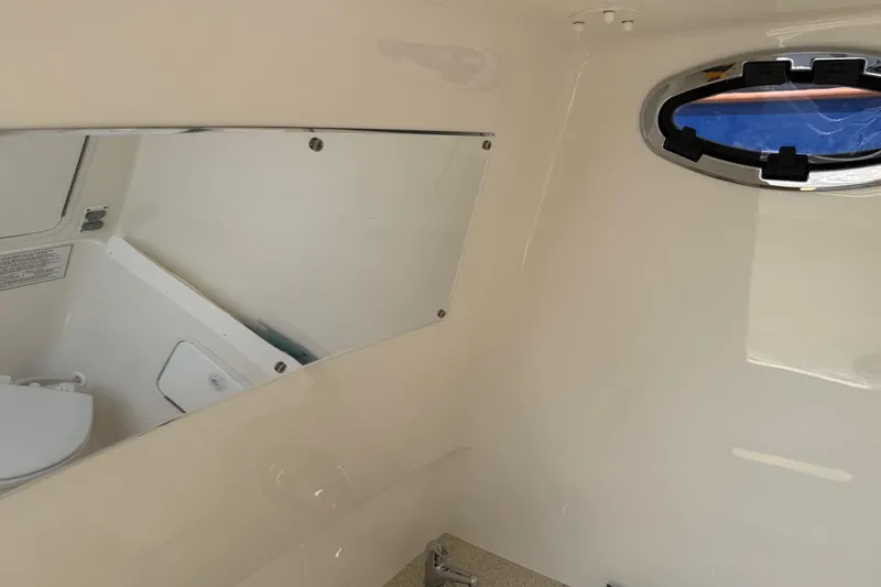  Yacht Photos Pics Interior of a 2018 Regulator 31 boat featuring a compact bathroom with a porthole.