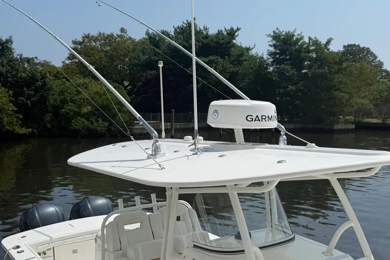  Yacht Photos Pics 2018 Regulator 31 boat with Garmin radar, docked by a tree-lined river.