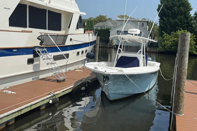  Yacht Photos Pics 2018 Regulator 31 boat docked beside a larger yacht in a marina.