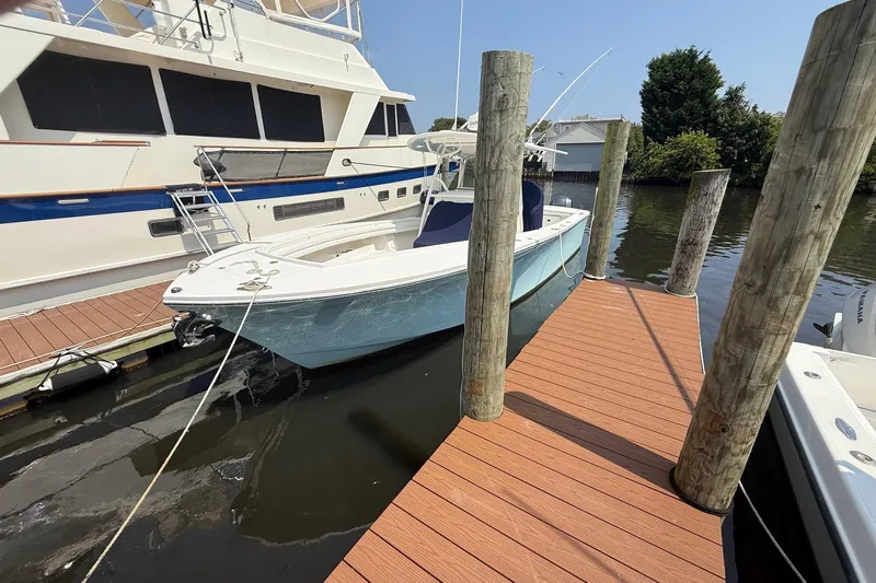  Yacht Photos Pics 2018 Regulator 31 boat docked beside a wooden pier on a sunny day.