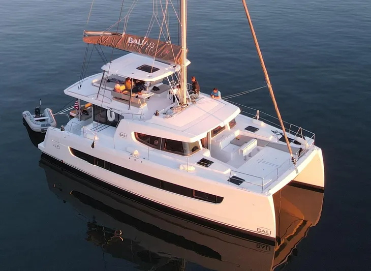 Neve Yacht Photos Pics 2022 Bali 4.6 catamaran sailing on calm waters at sunset.