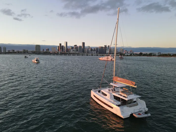 Neve Yacht Photos Pics Sailboat Bali 4.6 (2022) on water with city skyline in background at sunset.