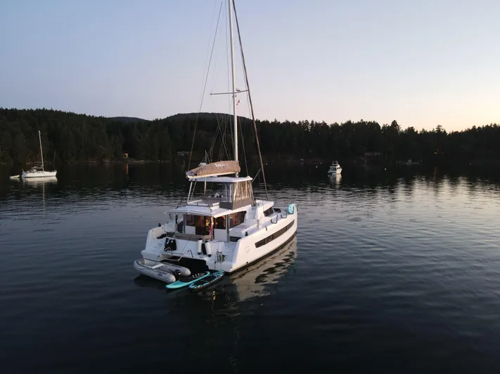 Neve Yacht Photos Pics Bali 4.6 catamaran anchored on calm water at sunset, 2022 model.