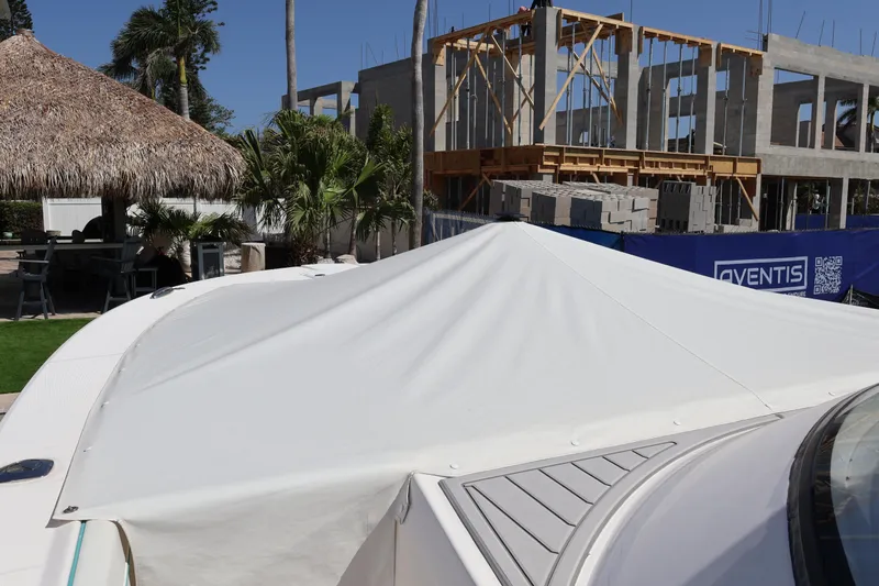  Yacht Photos Pics 2022 Regal 38 SAV boat with cover, near construction site and tropical setting.