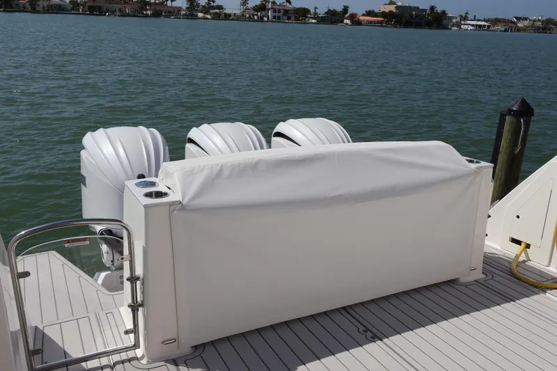  Yacht Photos Pics 2022 Regal 38 SAV boat with covered outboard engines on a sunny waterfront.