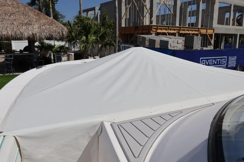  Yacht Photos Pics 2022 Regal 38 SAV boat with protective cover, construction site in background.