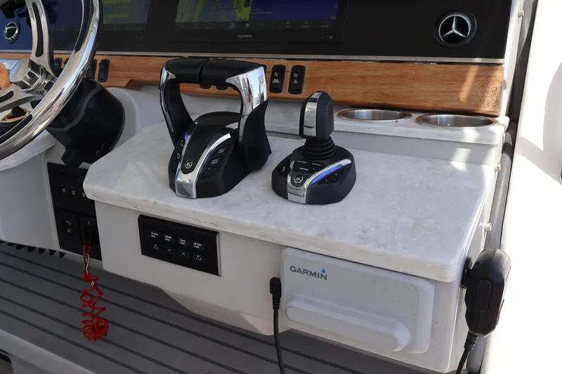  Yacht Photos Pics 2022 Regal 38 SAV helm with controls, steering wheel, and Garmin navigation system.