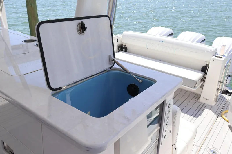  Yacht Photos Pics 2022 Regal 38 SAV boat with open storage compartment and seating area.