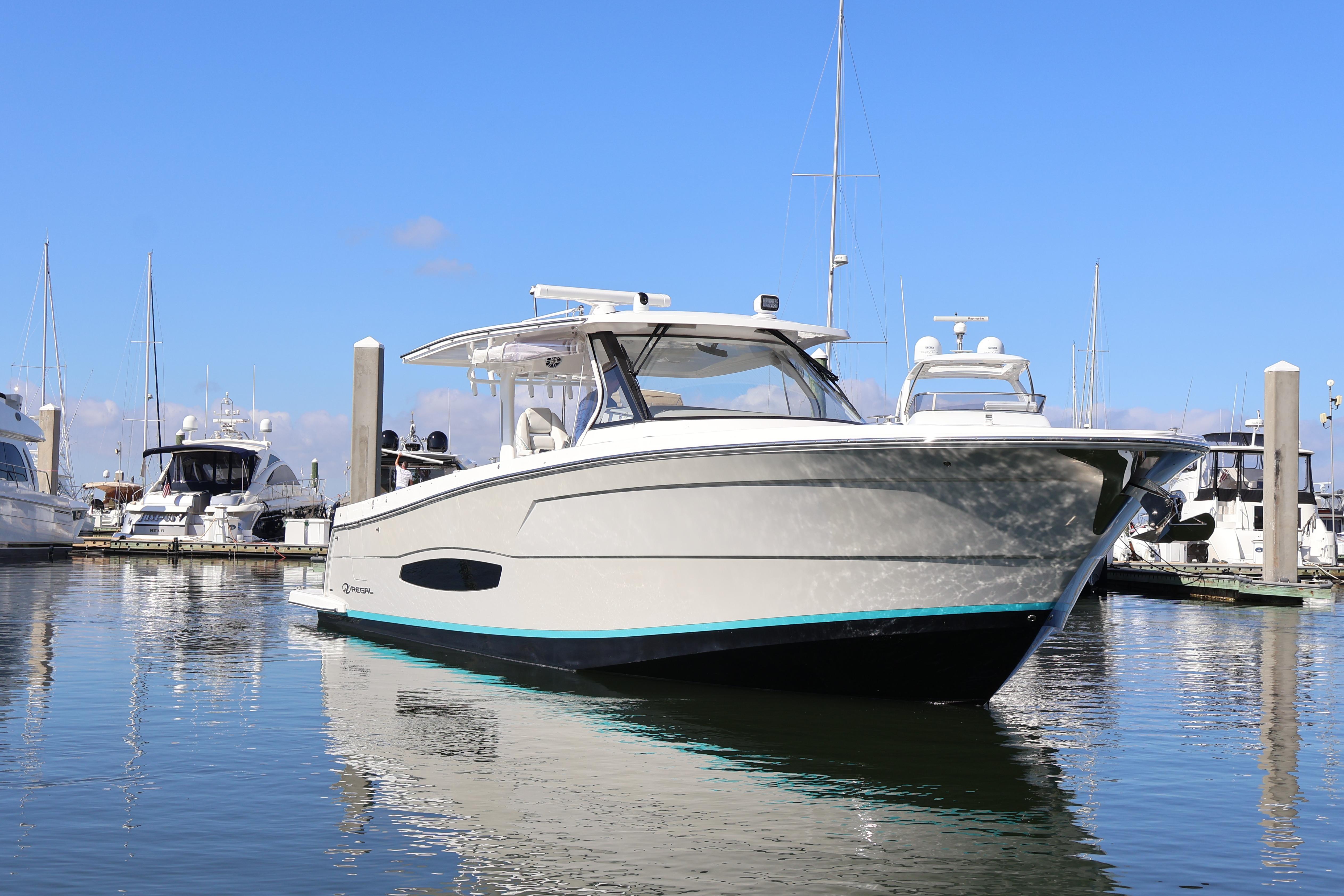 2022 Regal 38 SAV boat docked in marina, clear blue sky background.