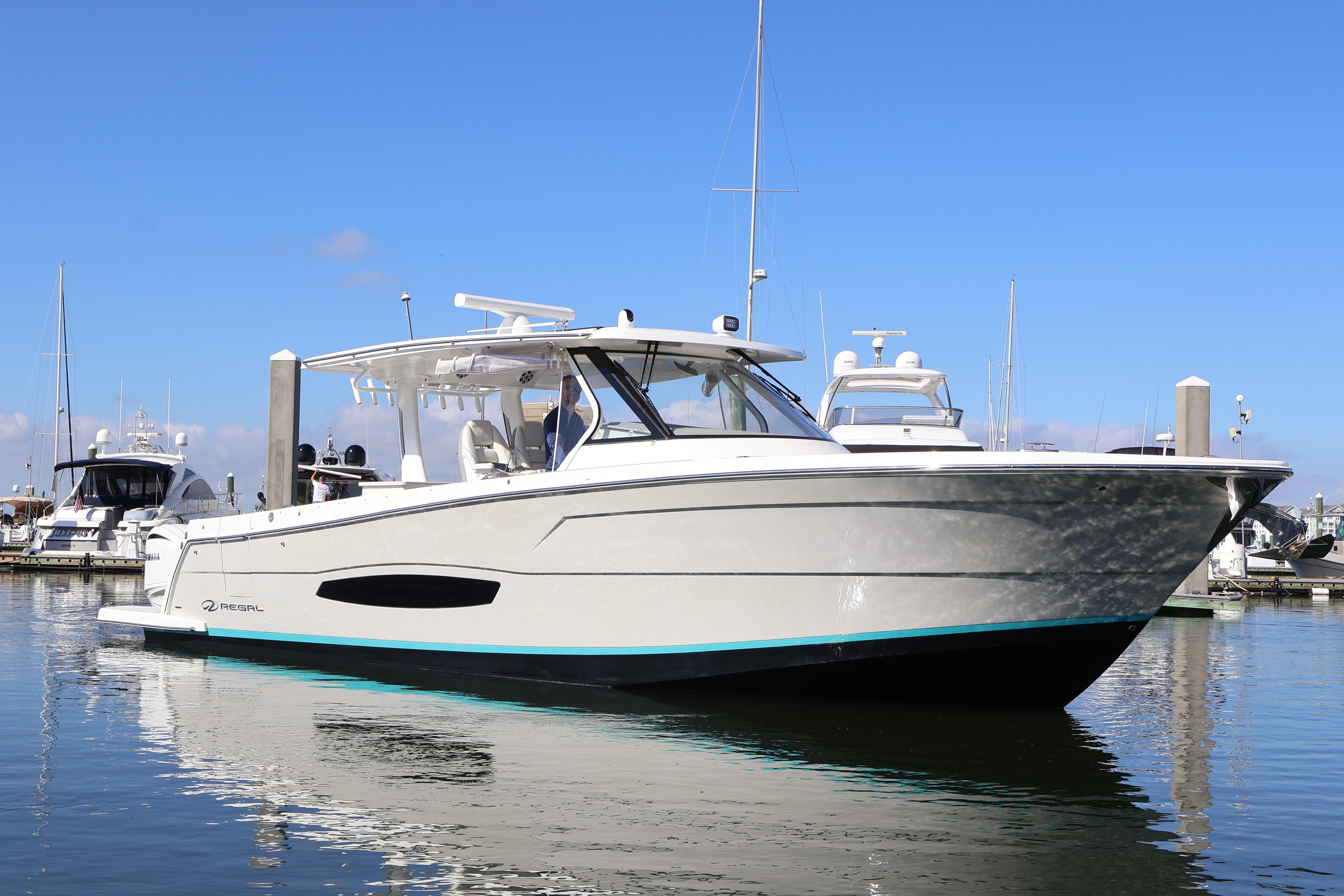 2022 Regal 38 SAV boat docked in marina under clear blue sky.