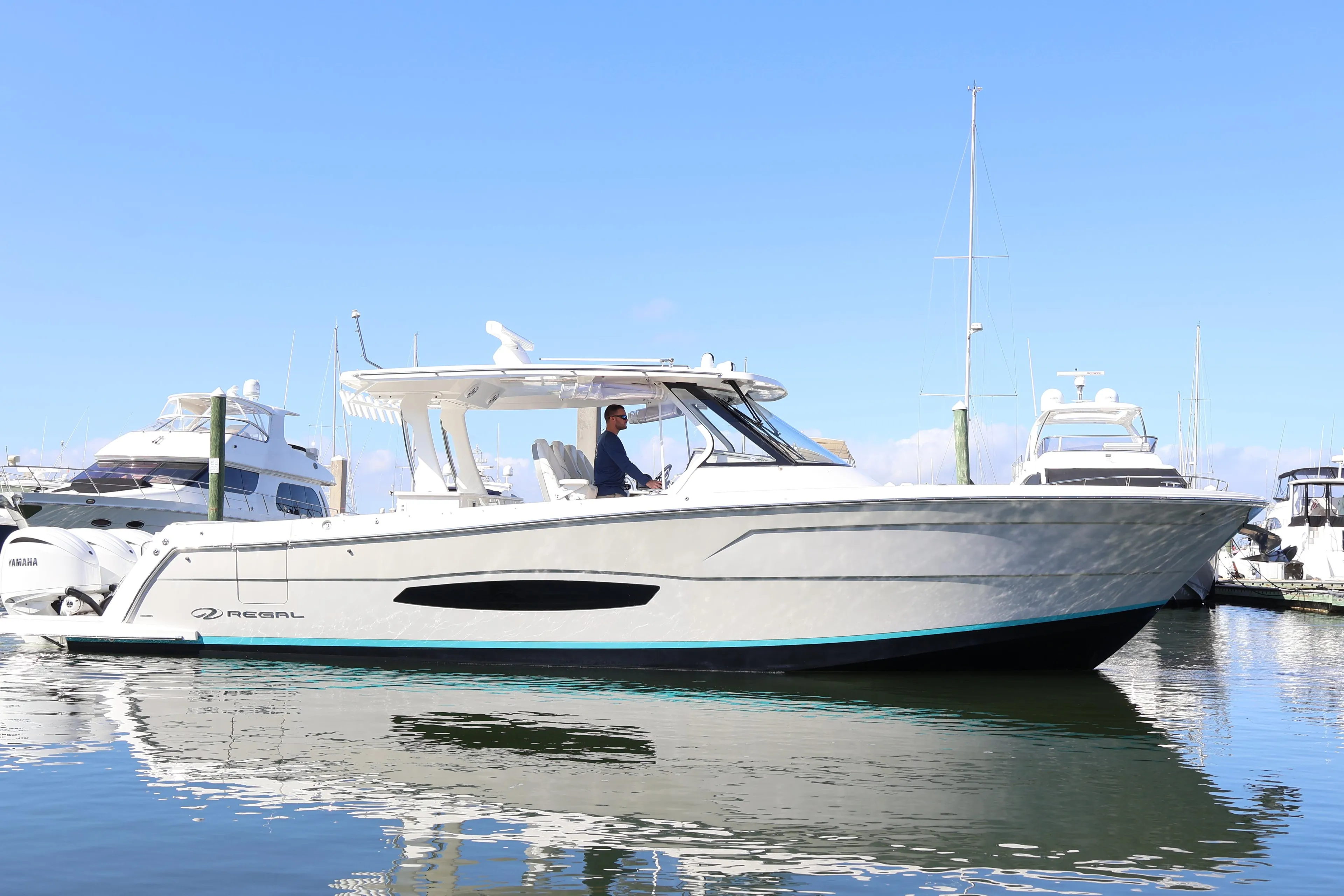 2022 Regal 38 SAV boat docked in marina, clear sky, calm water.
