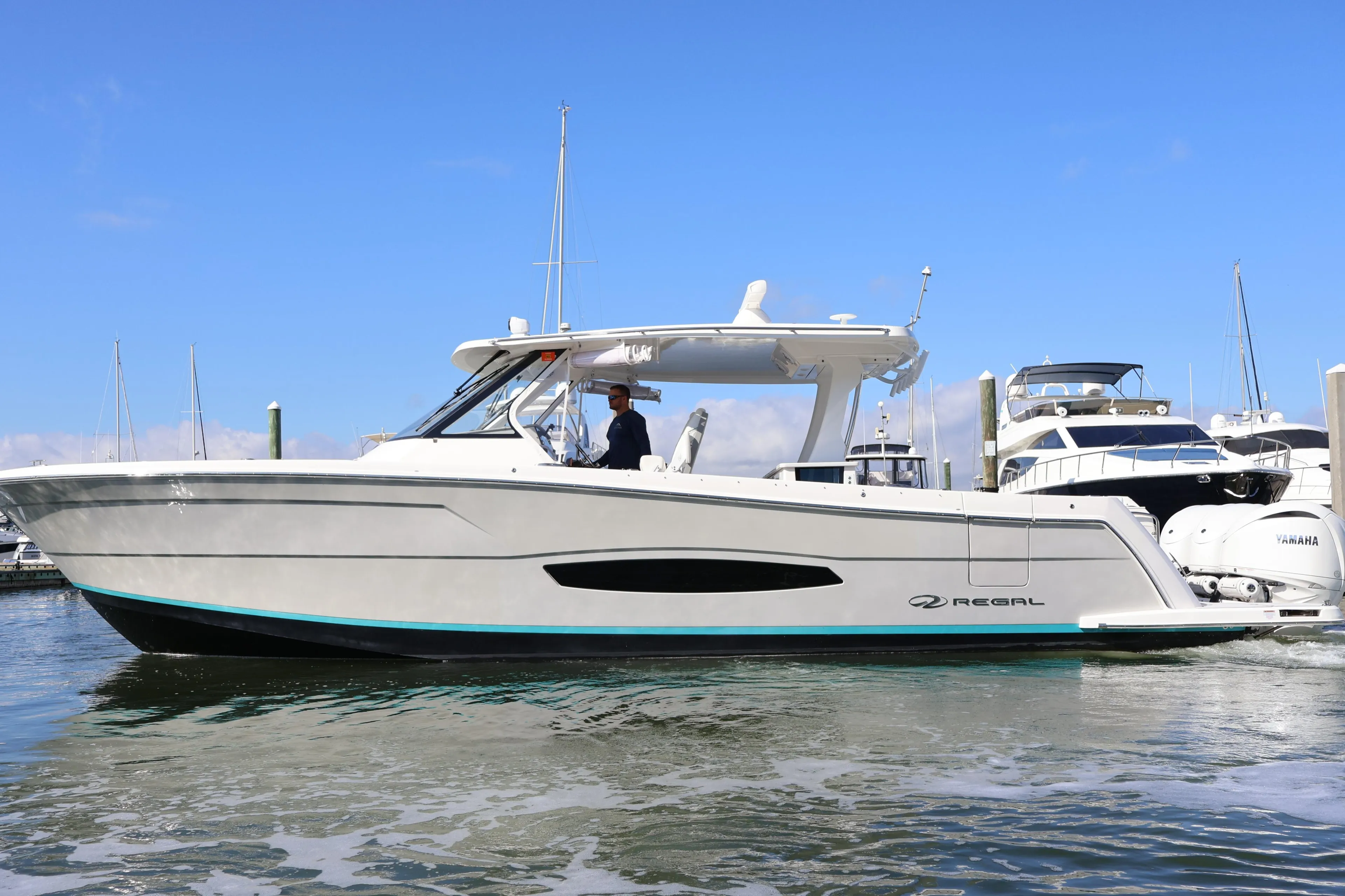 2022 Regal 38 SAV boat docked in marina, clear blue sky background.