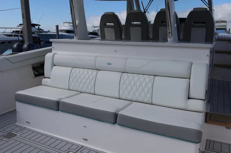  Yacht Photos Pics 2022 Regal 38 SAV boat seating area with luxurious white and gray upholstery.