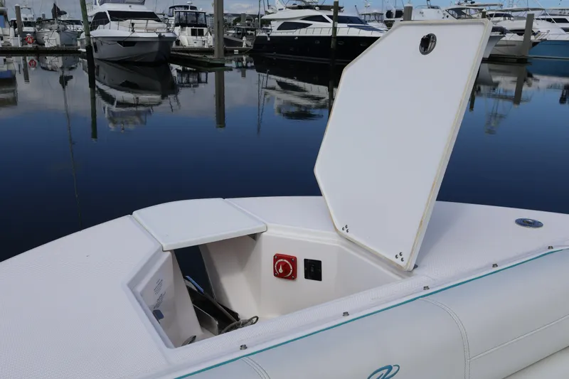  Yacht Photos Pics 2022 Regal 38 SAV boat with open storage compartment at marina.