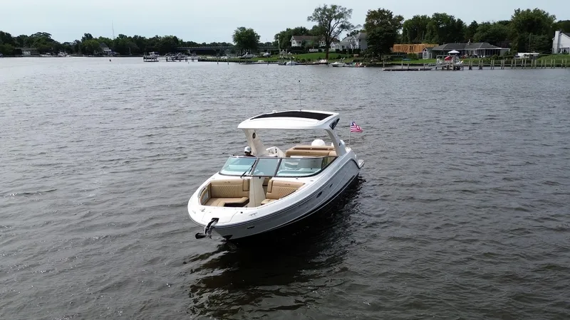  Yacht Photos Pics 2023 Sea Ray SLX 310 boat on a calm lake with shoreline in the background.