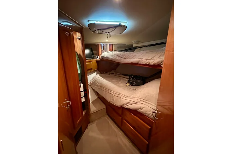 Dock Fee Yacht Photos Pics Cozy cabin interior of 1998 Viking 50 Convertible yacht with bunk beds and wooden cabinetry.