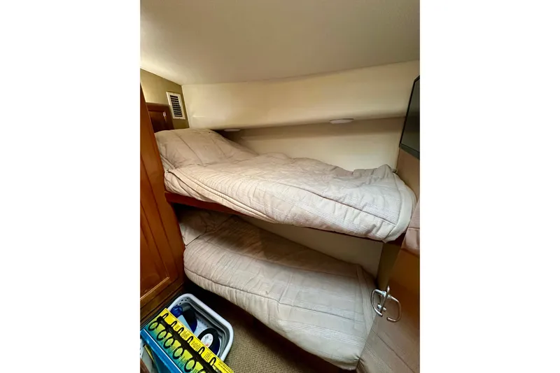 Dock Fee Yacht Photos Pics 1998 Viking 50 Convertible yacht interior with cozy bunk beds and wooden accents.